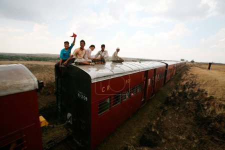 Téléchargez les photos : Passagers assis sur la ligne de chemin de fer à écartement supérieur à Miraj Maharashtra Inde Asie - en image libre de droit