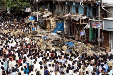 Photo for Policemen inspecting site of bomb blast also large number of people gathered to look at the site at Zaveri Bazaar in busy Kalbadevi area; Bombay Mumbai, Maharashtra, India On August 26th 2003 - Royalty Free Image