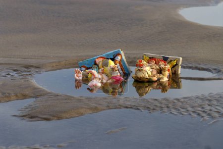 Téléchargez les photos : Idoles Ganesh couché dans l'eau polluée après immersion sur la plage Aksa ; Bombay Mumbai ; Maharashtra ; Inde - en image libre de droit