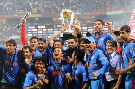 Téléchargez les photos : Les joueurs de cricket indiens célèbrent avec le trophée de la Coupe du monde ICC après avoir battu le Sri Lanka dans le match final de la Coupe du monde de cricket 2011 de l'ICC au stade Wankhede à Mumbai le 2 avril 2011. - en image libre de droit