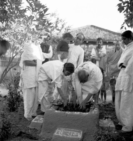 Foto de Mahatma Gandhi y su sobrina Abha Gandhi plantando un árbol tulsi en Sevagram Ashram, Vardha, Maharashtra, India, agosto 1944 - Imagen libre de derechos
