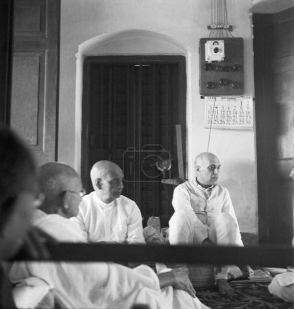 Téléchargez les photos : Sardar Vallabhbhai Patel et Jawaharlal Nehru écoutant un reportage sur les émeutes à Calcutta à Khadi Pratishthan, Sodepur, 24 Parganas, Calcutta, 1946. Inde - en image libre de droit