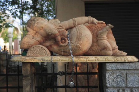 Foto de Ídolo de piedra del señor Ganesha en posición de dormir bloqueado por cadena de metal para la seguridad; Mahabalipuram; Distrito de Chengalpattu; Tamil Nadu - Imagen libre de derechos