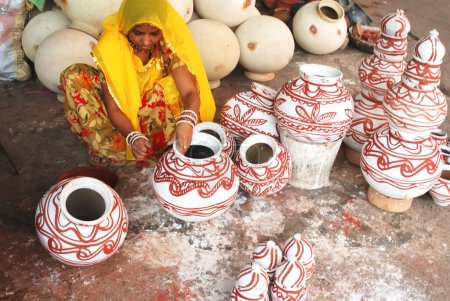 Photo for Potter woman painting on earthen pitcher, Jodhpur, Rajasthan, India - Royalty Free Image