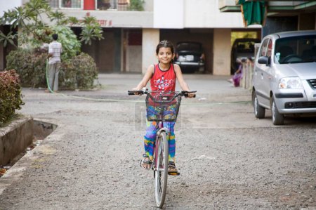 Foto de India del sur de Asia niña de siete años Sanchi montar en bicicleta, Bombay Mumbai, Maharashtra, India - Imagen libre de derechos