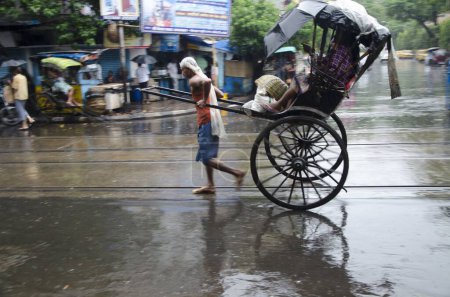 Photo for Man pulling Hand Rickshaw with passenger on street Kolkata West Bengal India Asia - Royalty Free Image