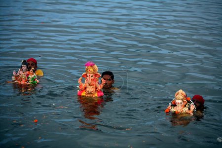 Téléchargez les photos : Idoles du Seigneur Ganesha ganpati divinité hindoue immergée dans le lac Powai ; Bombay Mumbai ; Maharashtra ; Inde - en image libre de droit