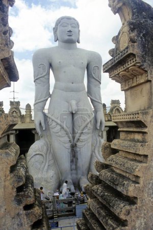Téléchargez les photos : Statue de de 58.8 pieds monolithique Statue de jain saint Gomateshwara (Lord Bahubali) en mahamastakabhisheka (cérémonie d'onction de la tête) sur la colline Vindhyagiri, Shravanbelagola, Karnataka, Inde - en image libre de droit