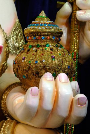 Photo for Hand of Lord Ganesh with Modak of Gold encrusted with gems ; Ganapati festival year 2008 Shree Tulsibaug Ganapati ; fourth in honour at Pune ; Maharashtra ; India - Royalty Free Image