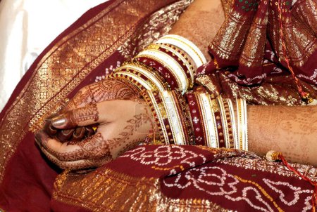 Mariée montrant des bracelets et des tatouages au henné lors de la cérémonie de mariage