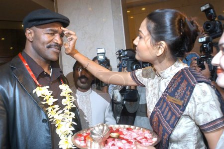 Téléchargez les photos : Quatre fois boxeur poids lourd Evander Holyfield qui est venu aux nouvelles après avoir été mordu par un autre boxeur poids lourd Mike Tyson lors du troisième tour d'un match de boxe en Juin 1997, est arrivé à Bombay maintenant Mumbai, à l'hôtel Leela Kempinski - en image libre de droit