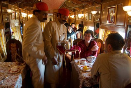 Téléchargez les photos : Accompagnateur Rajasthani servant aux touristes dans Heritage on Wheels Voyage dans le train touristique de luxe passé, Rajasthan, Inde - en image libre de droit