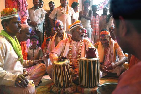 Photo for Indian devotees playing musical instrument tabla and singing Bhajans at Dauji Temple, Baldeo, Uttar Pradesh, India - Royalty Free Image