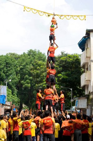 Foto de Pirámide humana rota dahi handi ducha de cuajada y agua cúrcuma en festival janmashtami en dadar, Bombay, Mumbai, Maharashtra, India - Imagen libre de derechos