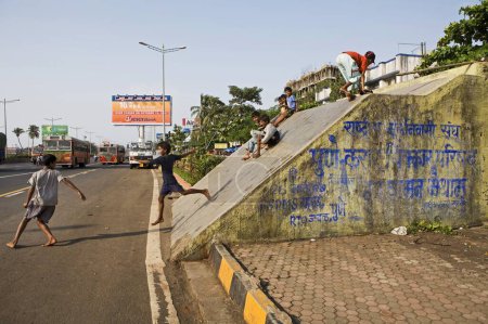 Foto de Techo inclinado del metro peatonal a lo largo de la concurrida autopista expreso occidental lugar peligroso para que los niños jueguen el juego de diapositivas, Mumbai Bombay, Maharashtra, India - Imagen libre de derechos