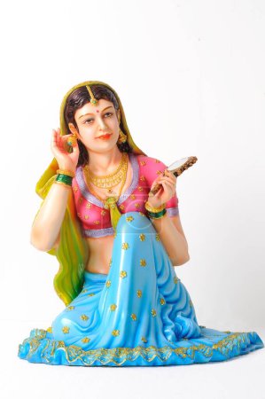 Clay figurine , statue of rajasthani young girl wearing earring with mirror in her left hand