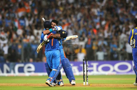 Téléchargez les photos : Le capitaine de cricket indien Mahendra Singh Dhoni R et son coéquipier Yuvraj Singh célèbrent après avoir battu le Sri Lanka lors du match final de la Coupe du monde de cricket 2011 de l'ICC au stade Wankhede à Mumbai le 2 avril 2011. - en image libre de droit
