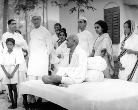 Téléchargez les photos : Mahatma Gandhi avec ses collègues Dr Sushila Nayar (deuxième à droite), son frère Pyarelal Nayer (à côté d'elle) et Mahadev Desai (troisième à gauche) à l'Ashram de Sodepur, Calcutta, Bengale occidental, Inde, avril 1939 - en image libre de droit