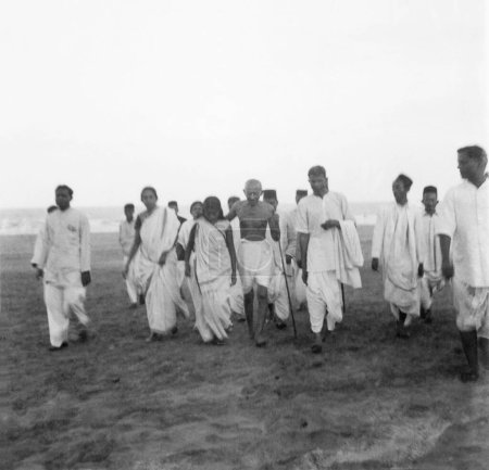 Téléchargez les photos : Mahatma Gandhi et d'autres marchant à Juhu Beach ; Mumbai ; mai 1944 ; Inde - en image libre de droit