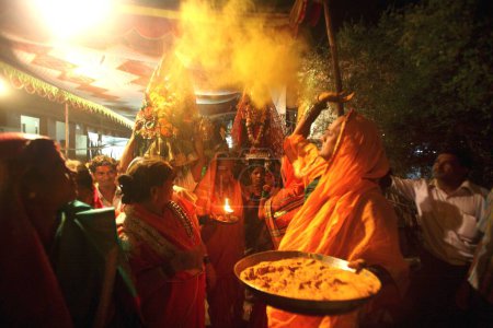 Foto de Cúrcuma o Haldi se unta en estatuas de bronce de dios y diosa Rishi Jamat Agni y Yellama durante la procesión; boda de eunucos con motivo de Bewa Purnima en Ghatkopar; Bombay ahora Mumbai; Maharashtra; India - Imagen libre de derechos