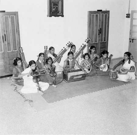 Photo for Old vintage 1900s black and white picture of blind children playing musical instruments harmonium tabla violin sitar India - Royalty Free Image