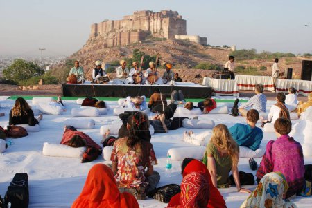 Téléchargez les photos : Touristes appréciant la musique folklorique pendant le festival Marwar, Jodhpur, Rajasthan, Inde - en image libre de droit