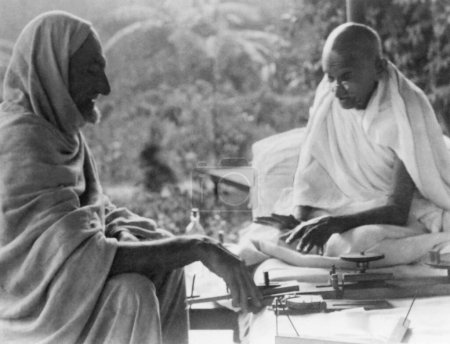 Téléchargez les photos : Khan Abdul Gaffar Khan et Mahatma Gandhi parlent de la philosophie de filature à Khadi Pratishthan ; Sodepur ; 24 Parganas ; Calcutta ; 1946 ; Inde - en image libre de droit