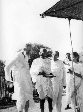 Téléchargez les photos : Mahatma Gandhi partage un rire chaleureux avec CF Andrews l, Pyarelal Nayar et d'autres à l'ashram de Sevagram, 1939 NO MR - en image libre de droit