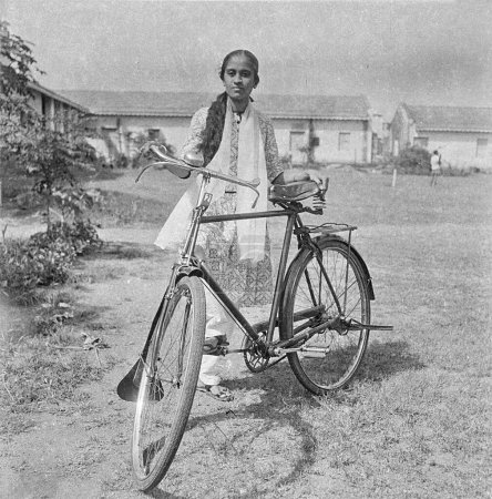 Téléchargez les photos : Vieux millésime 1900 noir et blanc photo de femme indienne vélo de fille portant salwar kameez Inde Années 1940 - en image libre de droit