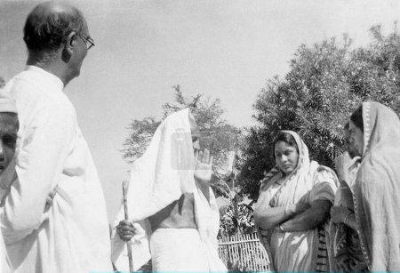 Foto de Mahadev Desai y Mahatma Gandhi con visitantes de Punjab en Sevagram Ashram, 1944 NO MR - Imagen libre de derechos