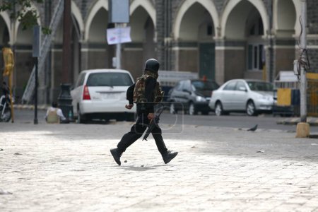 Foto de Guardias de Seguridad Nacional Comando del NSG corriendo durante el tiroteo con militantes dentro del Hotel Taj Mahal ataque terrorista por Deccan Mujahideen en Bombay Mumbai; Maharashtra; India 28-noviembre-2008 - Imagen libre de derechos