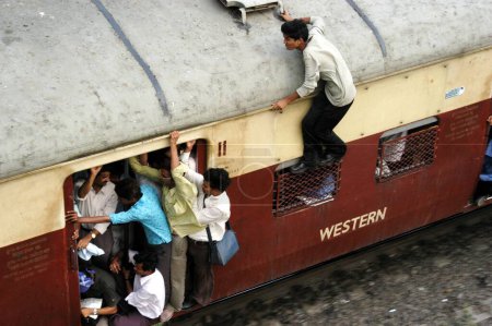 Photo for Boy commuting by standing on window due to crowd inside trains - Royalty Free Image
