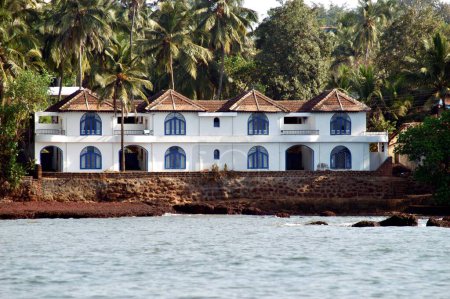 Weißes Haus im Hintergrund von Kokospalmen mit Manglorean-Fliesen in der Nähe von Dona Paula Jetty; Goa; Indien