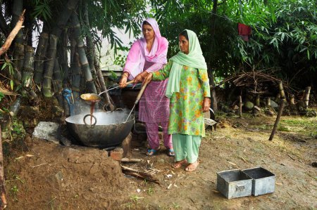 Foto de Mujeres rurales hirviendo ingredientes para hacer jabón lavado iniciativa económica iniciada por ONG Chinmaya Organización de Desarrollo Rural CORD, Sidhbari, Himachal Pradesh, India - Imagen libre de derechos