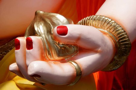 Eine Hand des Idols von Herrn Ganesh; der Elefant leitete Gott; mit einer Süßigkeit in seiner Handfläche, die Laddoo genannt wird; Ganesh ganpati Festival; Pune; Maharashtra; Indien 