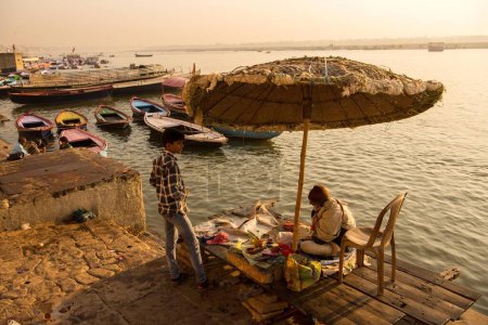 Téléchargez les photos : Prêtre assis sous un énorme parapluie à Dashashwamedh Ghat sur la rivière Ganga Ganges, Varanasi, Banaras, Benaras, Kashi, Uttar Pradesh, Inde - en image libre de droit