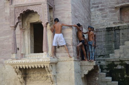 Foto de Los chicos se preparan para saltar en stepwell, jodhpur, rajasthan, india, asia - Imagen libre de derechos