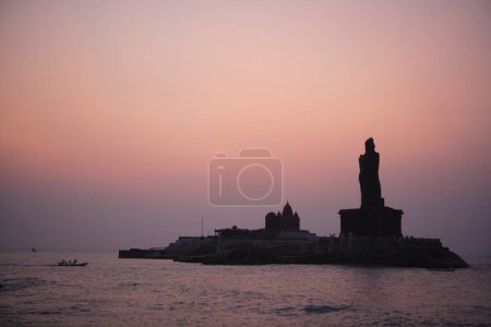 Téléchargez les photos : Vue du lever du soleil du Mémorial Vivekananda et statue du poète tamoul Thiruvalluvar situé sur les îles Rocheuses ; Kanyakumari ; Tamil Nadu ; Inde - en image libre de droit