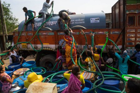 Téléchargez les photos : Personnes remplissant l'eau dans des fûts en plastique de citerne à eau, Bhiwandi, Maharashtra, Inde - en image libre de droit