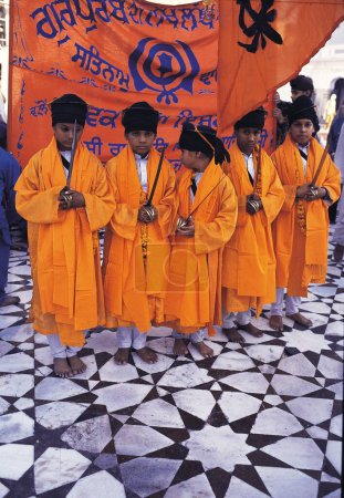 Foto de Niños en túnicas de azafrán, templo de oro, amritsar, punjab, india, asia - Imagen libre de derechos