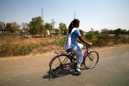 Young girl in salwar kameez with dupatta ;  school uniform ; going to school on bicycle in Bhopal ; Madhya Pradesh ; India