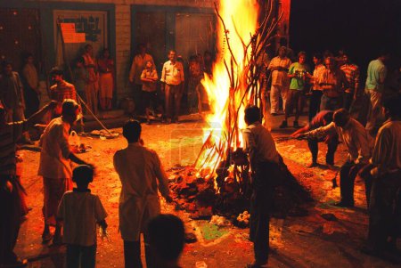 Téléchargez les photos : Les gens de cuisson plante de blé dans le feu de holika ; Jodhpur ; Rajasthan ; Inde - en image libre de droit