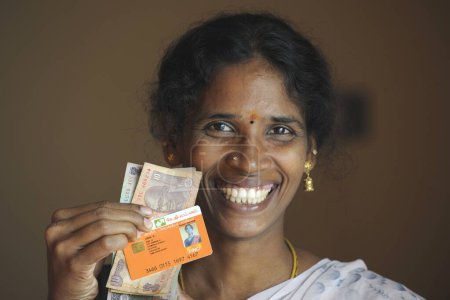 Foto de Señora rural mostrando efectivo y tarjeta de identidad del banco por ngo kshtriya gramin servicios financieros por la fundación IFMR; Thanjavur; Tamil Nadu; India NO MR - Imagen libre de derechos