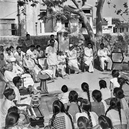 Photo for Old vintage 1900s black and white picture of village panchayat meeting men women harmonium tabla player Rajkot Gujarat India 1940s - Royalty Free Image