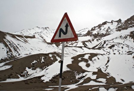 Foto de Letrero de curva inversa izquierda con montaña del Himalaya; Ladakh; Jammu y Cachemira; India 9-abril-2008 - Imagen libre de derechos