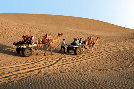 Photo for Tourists on camel cart safari, Khuhri, Jaisalmer, Rajasthan, India - Royalty Free Image