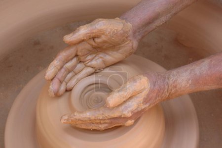 Foto de Cerámica; El kumbhar indio tradicional (alfarero) Fabricante de olla de barro de tierra; Hacer olla de arcilla en la rueda; Ejecución rural de los ingresos; Malewad; Shiroda; Sindhudurga; Maharashtra; India - Imagen libre de derechos
