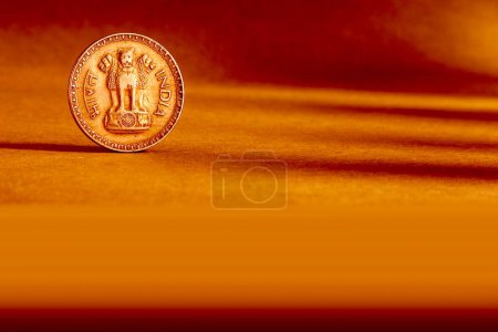 Foto de Una moneda india una rupias moneda trasera repujado Ashoka pilar símbolo nacional de emblema de estado sobre fondo naranja - Imagen libre de derechos