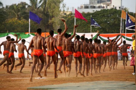 Téléchargez les photos : Police hommes saluant après avoir effectué Malkhamb gymnastique indienne sur 1 Mai Maharashtra jour de la fondation de l'État, Shivaji parc, Dadar, Bombay Mumbai, Maharashtra, Inde - en image libre de droit