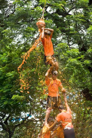 Foto de Pirámide humana rota dahi handi ducha de cuajada y agua cúrcuma en festival janmashtami en dadar, Bombay, Mumbai, Maharashtra, India - Imagen libre de derechos